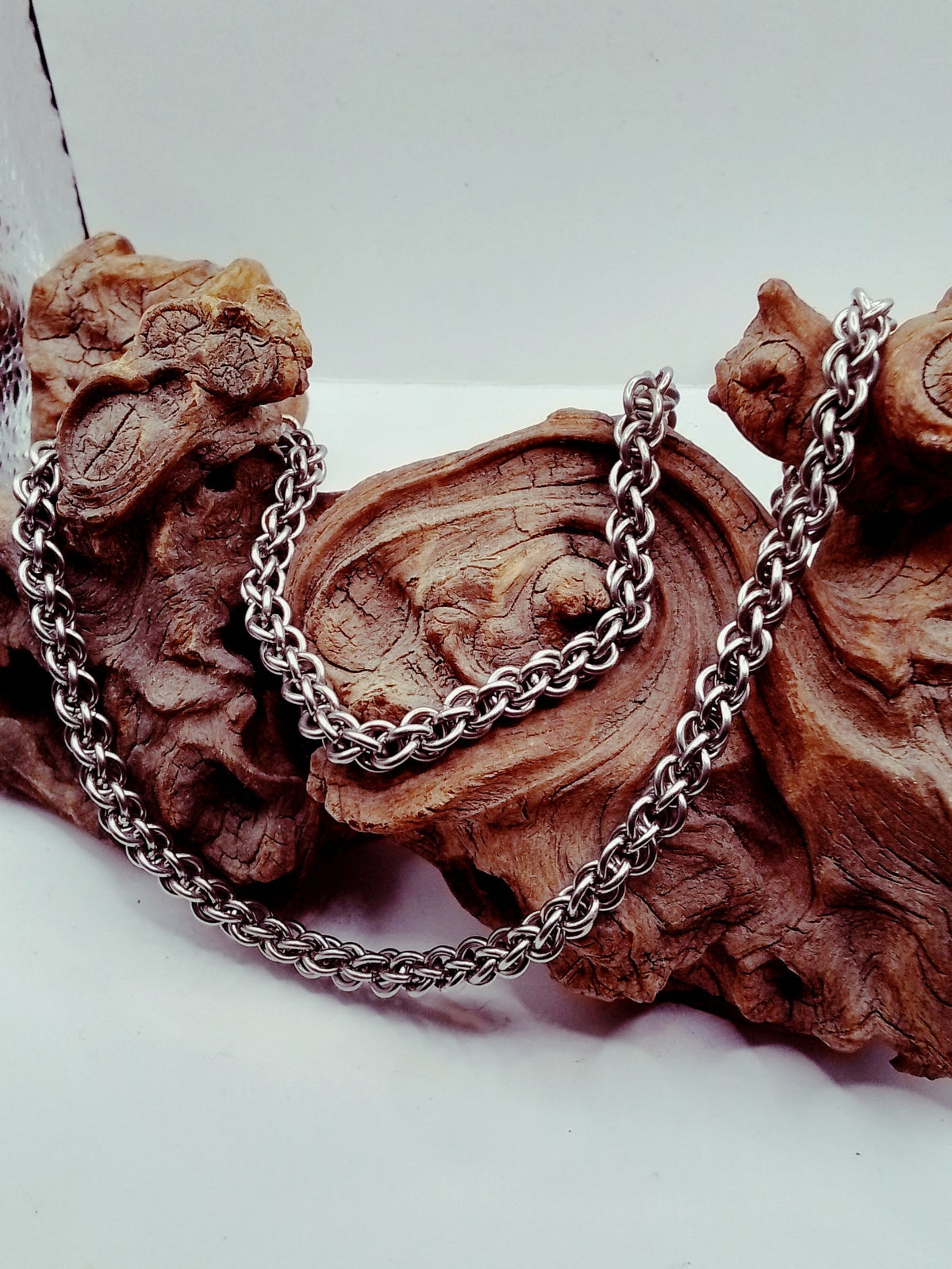Sanctuary Studio handcrafted stainless steel Jens Pind Linkage 3 chainmaille necklace draped over natural driftwood